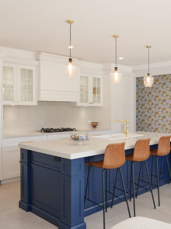 kitchen navy painted island with white upper cabinets and stone benchtop