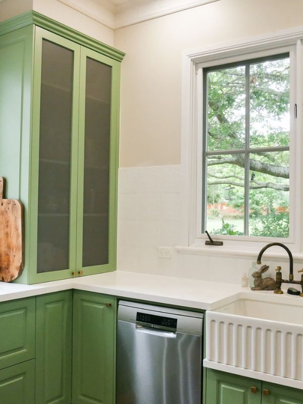 green painted country kitchen with mesh doors and farmhouse sink 