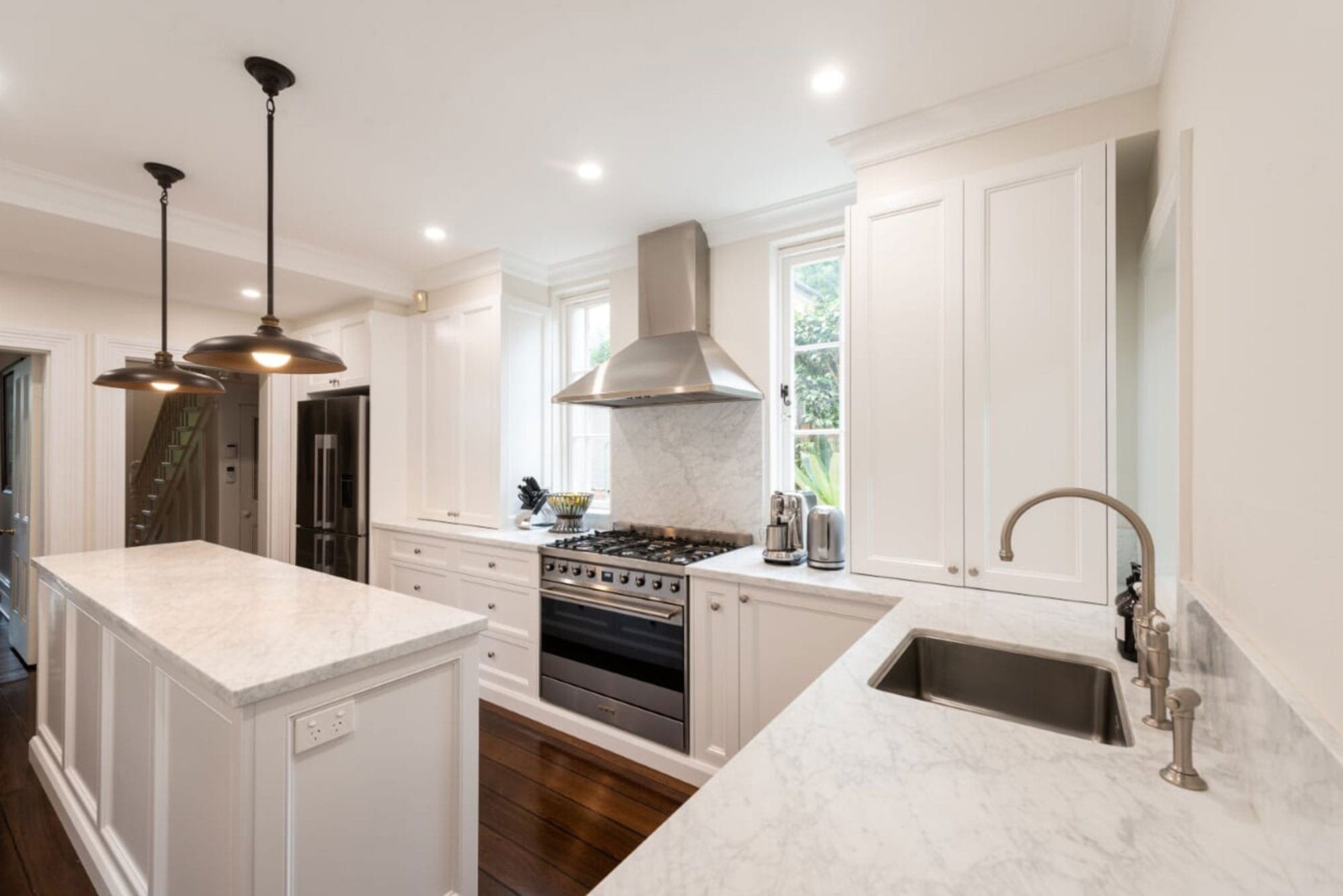 White classic kitchen with stainless steel appliances suited island. 